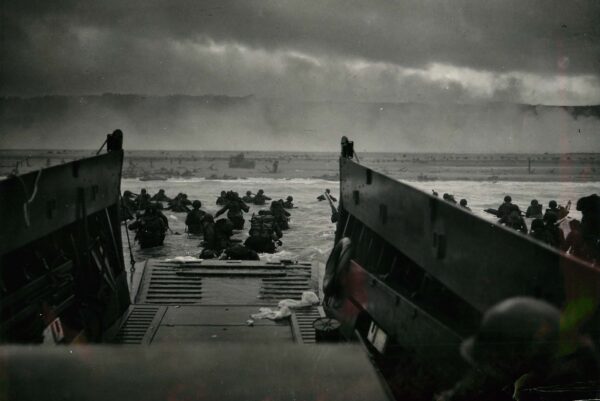 U.S. troops wade into the water as they stormed Omaha Beach on June 6, 1944. Photo take from the troop carrier with beachhead in the distance.
