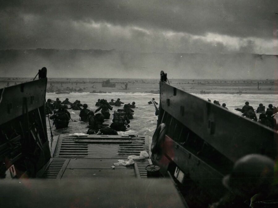 U.S. troops wade into the water as they stormed Omaha Beach on June 6, 1944. Photo take from the troop carrier with beachhead in the distance.