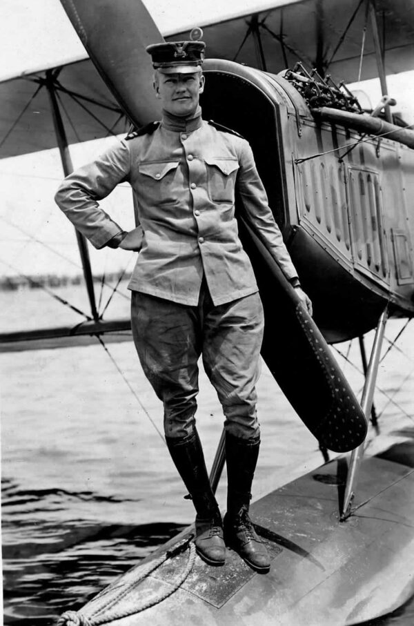 Photo: Coast Guard Second Lt. Philip Eaton photographed at the U.S. Navy’s flight training school in Pensacola, Florida. Standing in front of plane propeller. Photo in black and white.