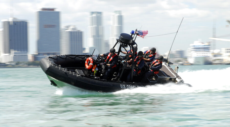 Photo: A Coast Guard boat making a high-speed turn in the ocean with the Miami skyline in the background.