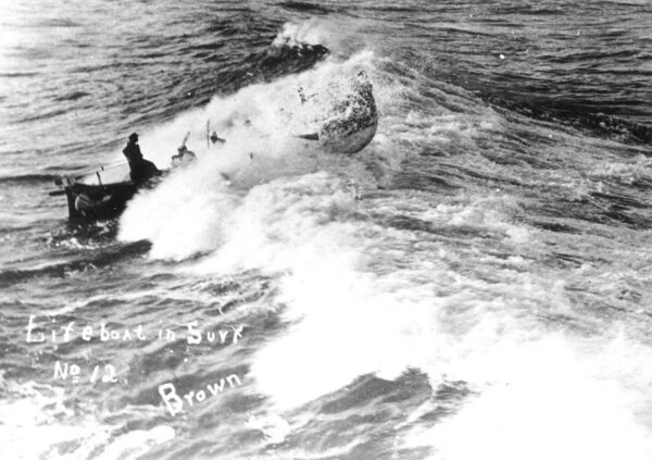 Photo of lifeboat breaking the waves, with writing “Life boat in surf No. 12, Brown”