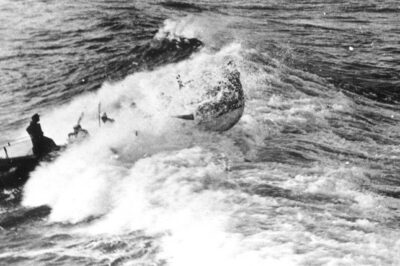 Photo of lifeboat breaking the waves, with writing “Life boat in surf No. 12, Brown”