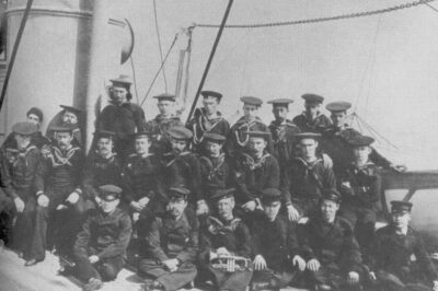 Early photograph of crewmembers of the Bering Sea Patrol cutter Bear with Asian national crew members seated in the bottom row.