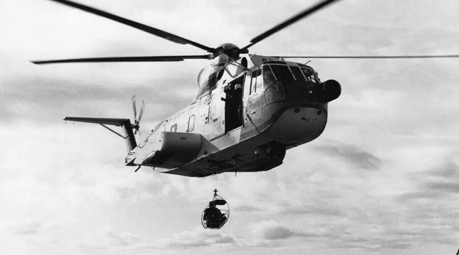 A vintage photo of a Coast Guard HH-3F “Pelican” making a hoist at sea.