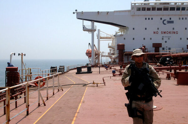 Photo: An armed LEDET team member walks the deck of a supertanker.