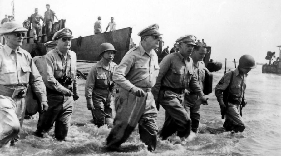 Photo: General Douglas Macarthur disembarks on the beaches of Leyte Island, seen walking with his staff.