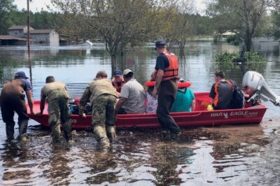 Photo: A small red motorboat loaded with area residents.