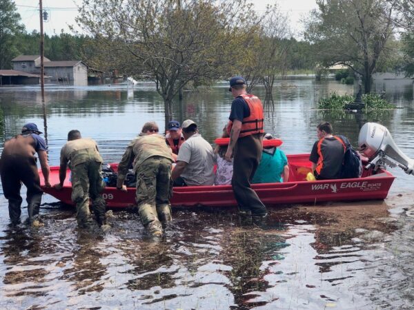 Photo: A small red motorboat loaded with area residents.