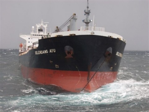 Photo: Frontal view of cargo vessel Selendang Ayu riding at anchor in heavy seas.