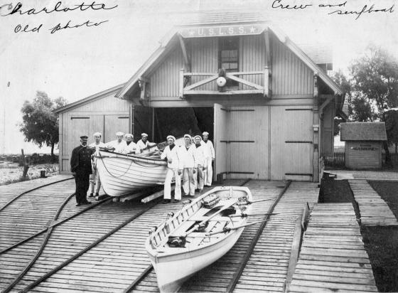 Photo: Keeper and crew pose with boat at their station.