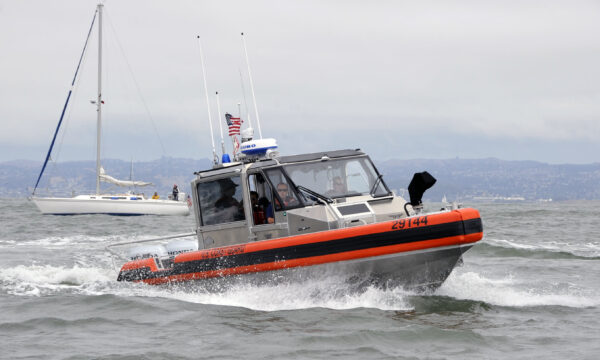 Photo: Patrol boat with sailboat in background.