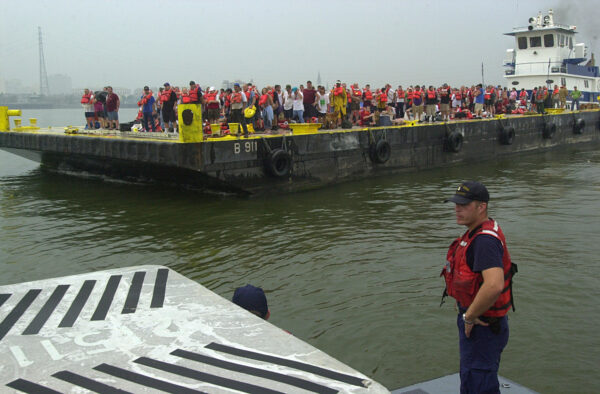 Photo: Cuttermen stands in the foreground while further away a barge carries refugees.