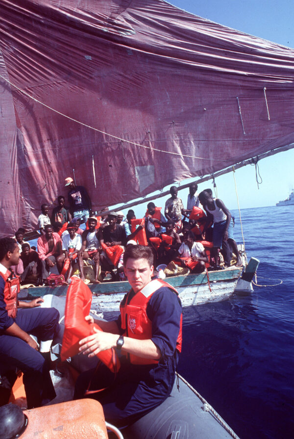 Photo: Coast Guard personnel approach a small boat with Haitian refugees.