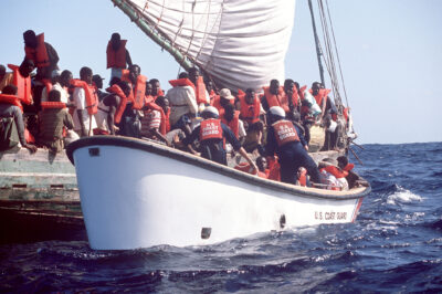 Photo: Haitian refugees scramble to get aboard a Coast Guard small boat after spending several days at sea.