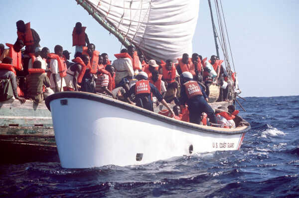 Photo: Haitian refugees scramble to get aboard a Coast Guard small boat after spending several days at sea.