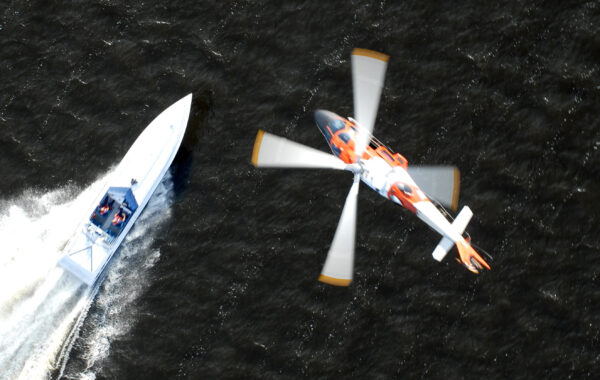 Photo: HITRON Training – a Coast Guard helicopter maneuvers over a tactical training fast boat.