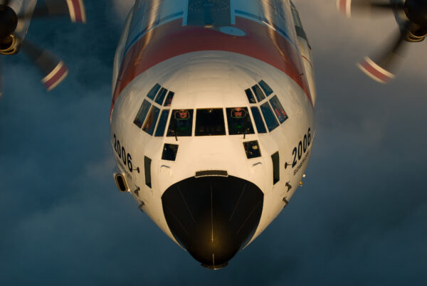 Photo: In air photo of C-130J showing a closeup of the nose, cockpit and pilots.