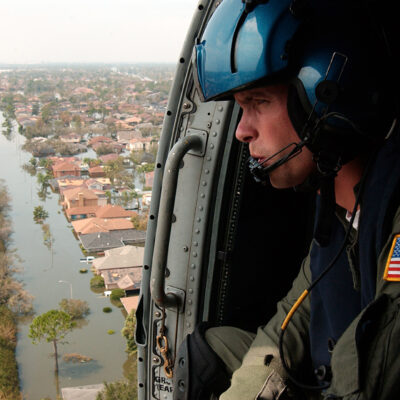 Photo: Coast Guardsman Shawn Beaty looks for Hurricane Katrina survivors from his HH-60 Jayhawk helicopter.