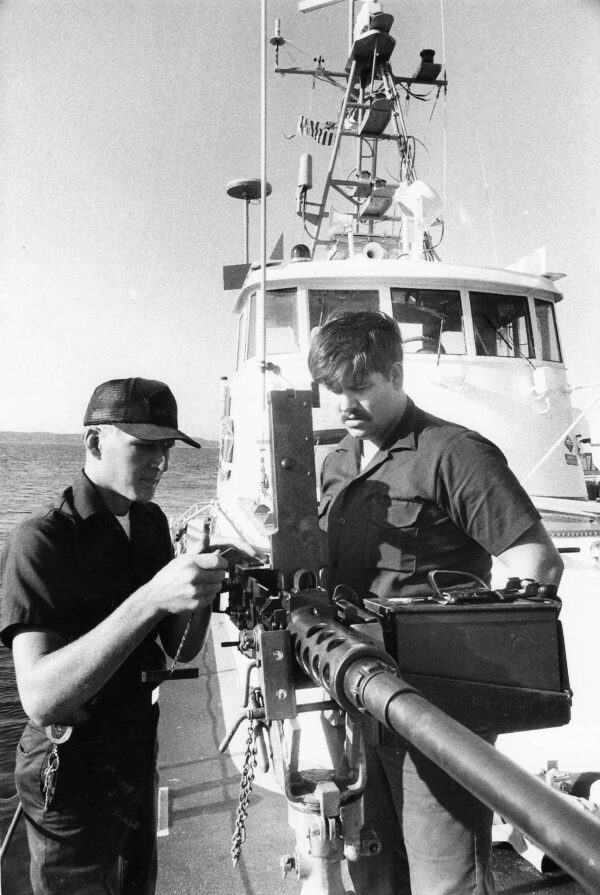 Photo: Crew members handle large machine gun.