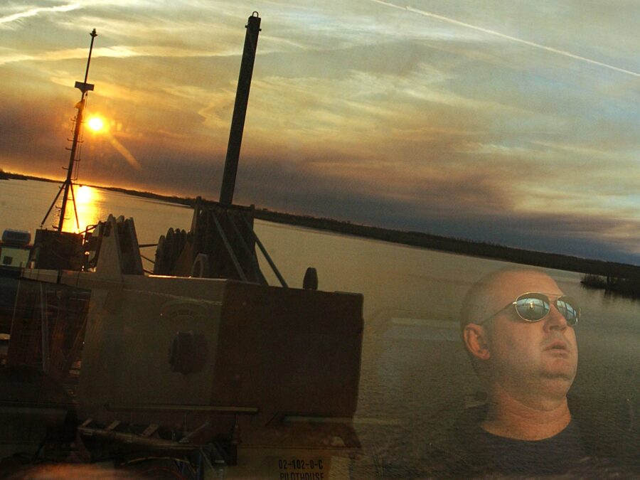Photo: Reflection of view from the bridge with crewmember visible through the glass.
