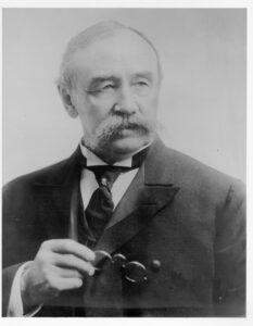 Photo: Older Sumner Kimball holding his glasses.