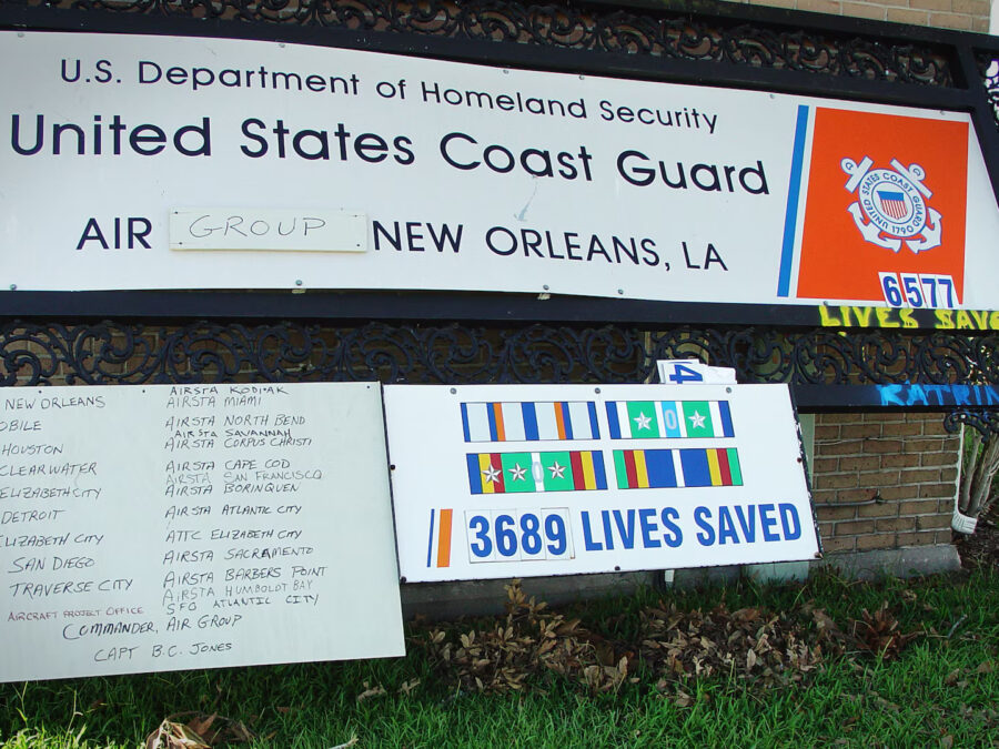 Photo: U.S. Coast Guard Air Station New Orleans sign leaning against a building after hurricane Katrina made landfall in August 2005.