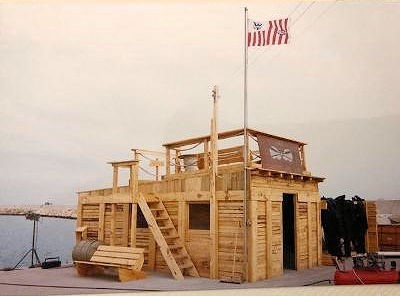 Photo: A small wooden building with the Coast Guard flag waving above.