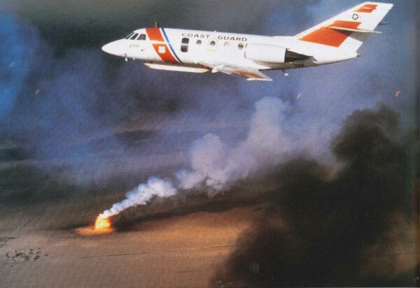 Photo: A Coast Guard Falcon jet flies above burning oil wells.