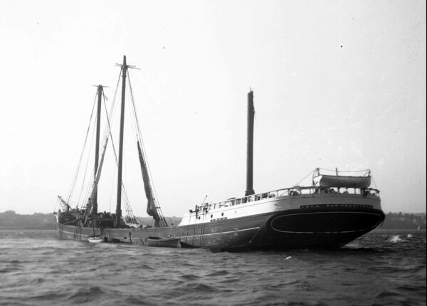 Photo: Port view of damaged schooner with broken mast.