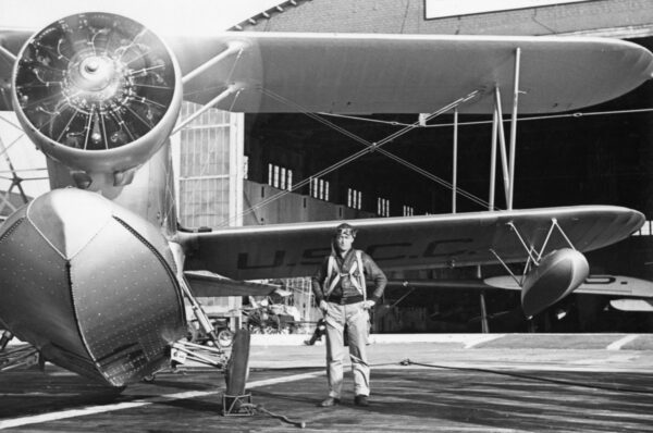 Photo: Lt. Richard Burke posing next to the spinning propeller of a Grumman J2F “Duck,”