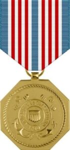 Color photo of a gold medal with a ribbon containing blue, red, and white stripes.