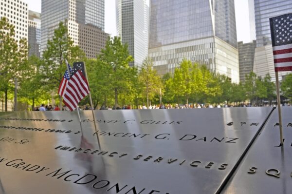 Photo: Memorial with miniature flags and view of downtown Manhattan.