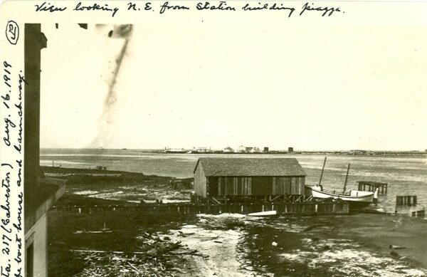 Photo: Building with boat in dry-dock adjacent to shore. Written text caption: [partially obscured]..ta. 217 (Galveston) Aug. 16. 1919. The boat house and launchway. View looking N.E. from station building piazza.