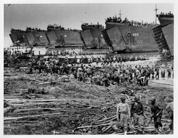 Photo: LSTs debarking troops and supplies on the beach.