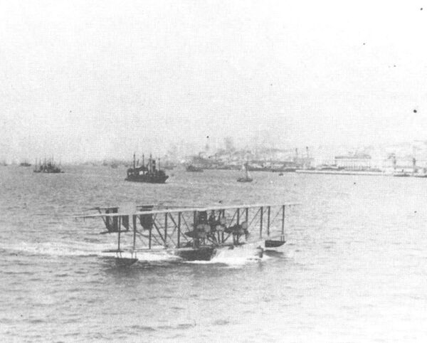 Photo: Amphibious bi-plane in taxiing in water.