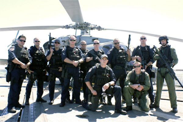 Photo: Team photo posing in front of helicopter.