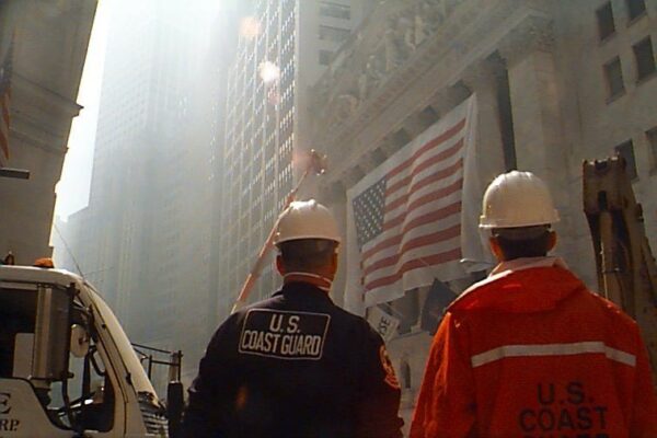 Two men in hard hats standing at Wall Street near Ground Zero.