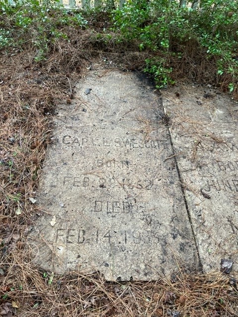 Photo: A worn gravestone uncovered from ground detritus