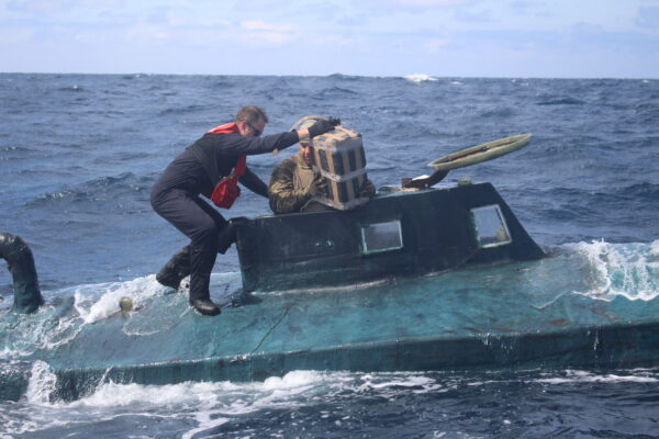 Photo: Coast Guard boarding team members climb aboard a 40-foot self-propelled semi-submersible (SPSS)