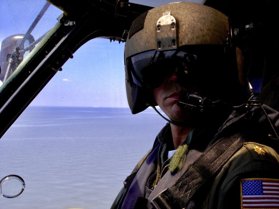 Photo: Lt. Cmdr. Jim O’Keefe in the co-pilot seat of a Coast Guard helicopter during flight operations over water.