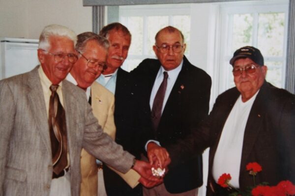 Photo: Four senior men pose together.