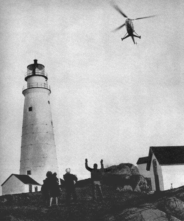 Photo: Helicopter approaches for landing near lighthouse.