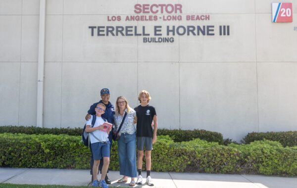 Photo: Rachel Horne and her sons in front of a building.