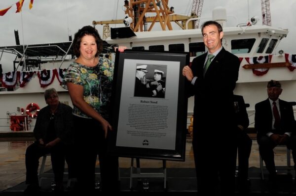 Photo: Lori Geddis receives framed commemoration.