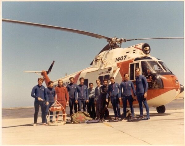 Photo: Color group photograph of the SARWET team in wetsuits posed in front of an HH-52 helicopter (number 1407) at Air Station San Francisco.