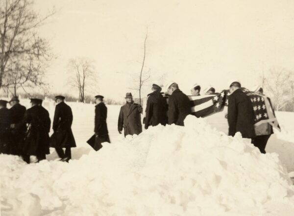 Photo: Funeral party carries flag-draped casket over deep snow