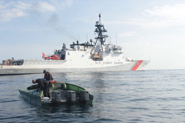 Photo: James’ boarding team examine commandeered low-profile vessel. Rear view highlights 3 powerful outboard motors.