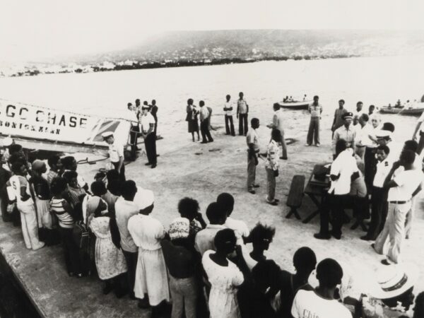 A photograph showing Haitians from the Exoribe returned to Port-au-Prince and waiting to have their names called by representatives of the Haitian Red Cross