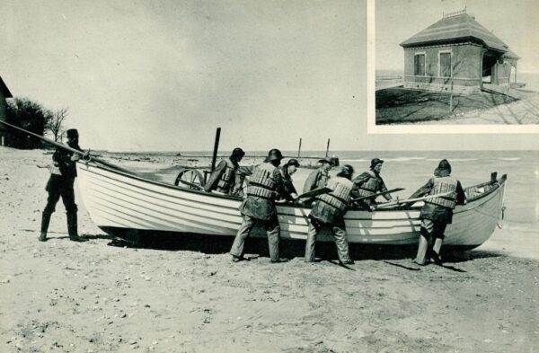 Photo: Men pulling boat ashore.