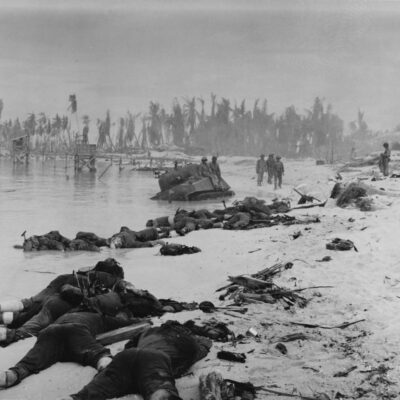 Photo: Bodys of fallen marines litter the beach as survivors walk in the distance.